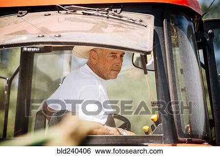 Stock Photograph - Caucasian farmer driving tractor. Fotosearch