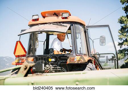 Caucasian farmer driving tractor View Large Photo Image Stock Photography - Caucasian farmer driving tractor. Fotosearch