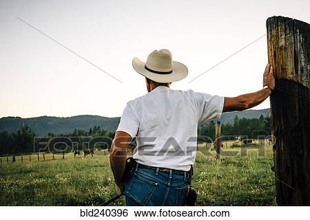 Caucasian farmer leaning on wooden post View Large Photo Image Stock Photograph - Caucasian farmer leaning on wooden post. Fotosearch