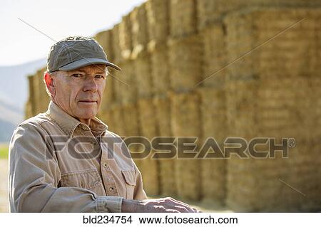 Caucasian farmer near stacks of hay View Large Photo Image Picture - Caucasian farmer near stacks of hay. Fotosearch