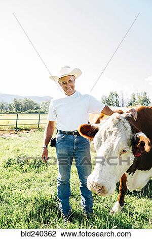 Caucasian farmer petting cow View Large Photo Image Stock Image - Caucasian farmer petting cow. Fotosearch