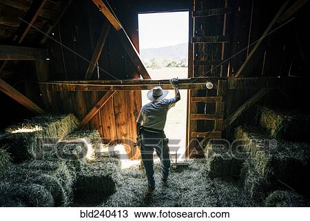Caucasian farmer resting in barn near bales of hay View Large Photo Image Stock Image - Caucasian farmer resting in barn near bales of hay. Fotosearch