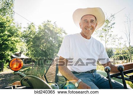 Caucasian farmer sitting on tractor View Large Photo Image Stock Photography - Caucasian farmer sitting on tractor. Fotosearch