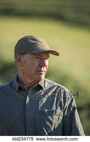 Stock Photo - Caucasian farmer standing in field. Fotosearch