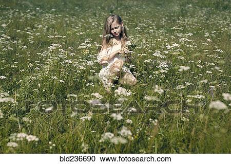 Caucasian girl crouching in field picking wildflowers View Large Photo Image Stock Image - Caucasian girl crouching in field picking wildflowers. Fotosearch