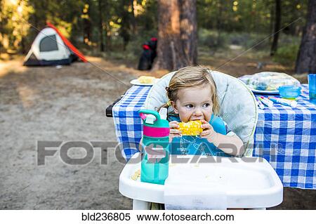 Caucasian girl eating corn in high chair View Large Photo Image Stock Photography - Caucasian girl eating corn in high chair. Fotosearch