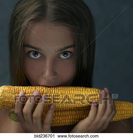 Stock Image - Caucasian girl eating corn on cob. Fotosearch