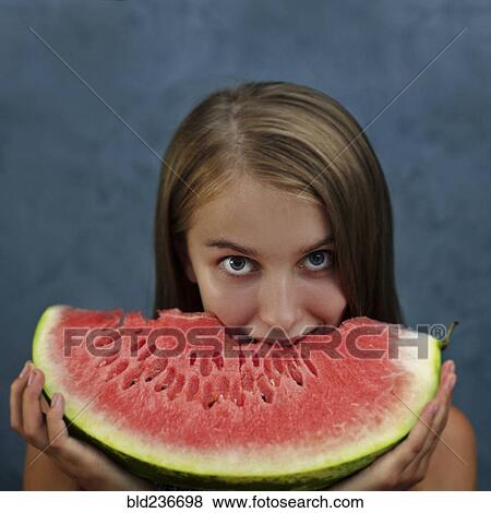 Caucasian girl eating enormous slice of watermelon View Large Photo Image Stock Photo - Caucasian girl eating enormous slice of watermelon. Fotosearch