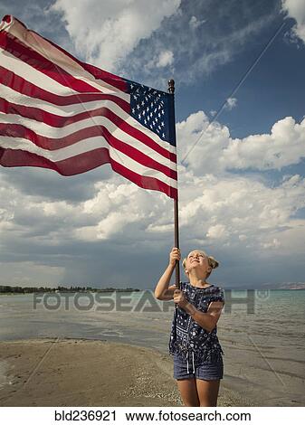 Caucasian girl holding American flag at beach View Large Photo Image Stock Image - Caucasian girl holding American flag at beach. Fotosearch