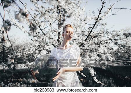 Stock Image - Caucasian girl holding bubble helmet. Fotosearch
