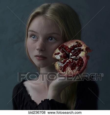 Caucasian girl holding pomegranate slice to cheek View Large Photo Image Stock Photo - Caucasian girl holding pomegranate slice to cheek. Fotosearch
