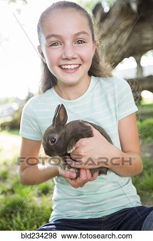 Caucasian girl holding rabbit View Large Photo Image Stock Photo - Caucasian girl holding rabbit. Fotosearch