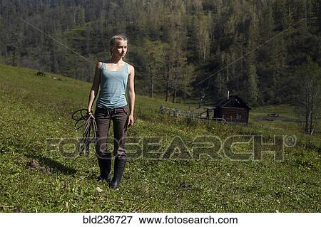 Stock Photo - Caucasian girl holding rope on hill. Fotosearch