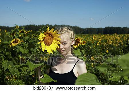 Caucasian girl holding sunflower View Large Photo Image Stock Photo - Caucasian girl holding sunflower. Fotosearch