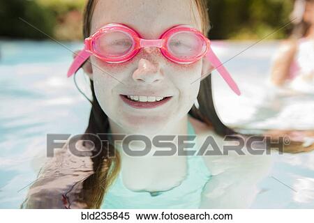Stock Photography - Caucasian girl in swimming pool wearing goggles. Fotosearch