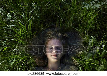 Stock Photography - Caucasian girl laying in grass. Fotosearch