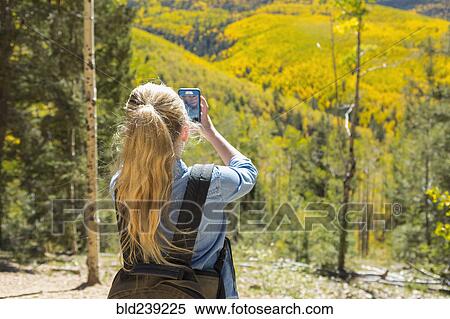 Caucasian girl photographing scenic view with cell phone View Large Photo Image Stock Photography - Caucasian girl photographing scenic view with cell phone. Fotosearch