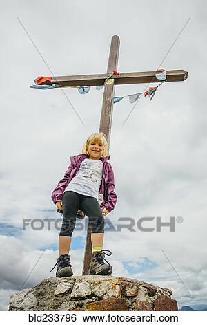 Stock Photograph - Caucasian girl posing on rock at crucifix. Fotosearch