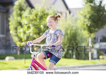 Stock Photography - Caucasian girl riding bicycle. Fotosearch