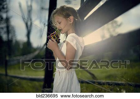 Caucasian girl smelling bouquet of wildflowers near wooden fence View Large Photo Image Stock Photography - Caucasian girl smelling bouquet of wildflowers near wooden fence. Fotosearch