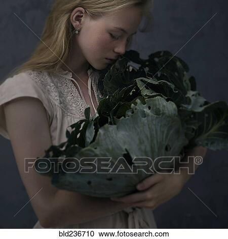 Caucasian girl smelling leafy green lettuce View Large Photo Image Stock Image - Caucasian girl smelling leafy green lettuce. Fotosearch