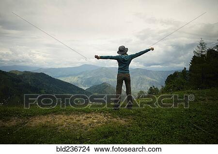 Caucasian girl stretching arms on mountain range View Large Photo Image Picture - Caucasian girl stretching arms on mountain range. Fotosearch