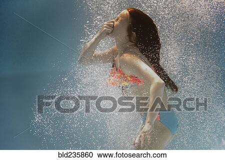 Caucasian girl swimming underwater holding nose View Large Photo Image Stock Image - Caucasian girl swimming underwater holding nose. Fotosearch