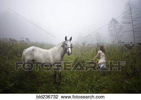 Caucasian girl walking horse in foggy field View Large Photo Image Stock Image - Caucasian girl walking horse in foggy field. Fotosearch