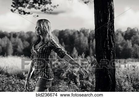 Picture - Caucasian girl walking near tree. Fotosearch