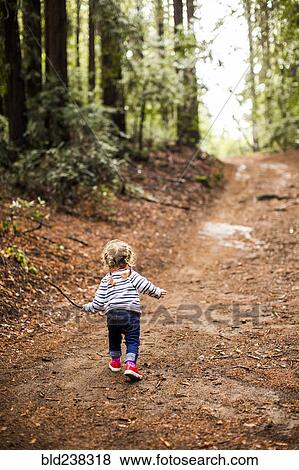 Caucasian girl walking on forest path View Large Photo Image Stock Photo - Caucasian girl walking on forest path. Fotosearch