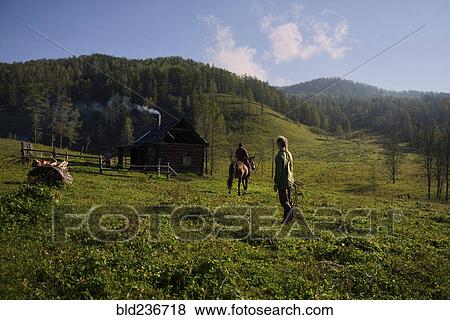 Caucasian girl watching girl riding horse View Large Photo Image Stock Photo - Caucasian girl watching girl riding horse . Fotosearch