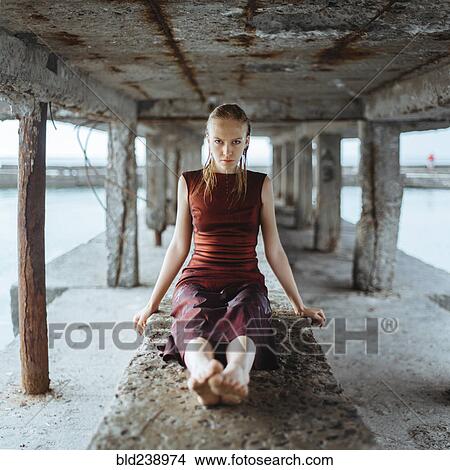 Caucasian girl wearing wet dress sitting underneath dock View Large Photo Image Picture - Caucasian girl wearing wet dress sitting underneath dock. Fotosearch