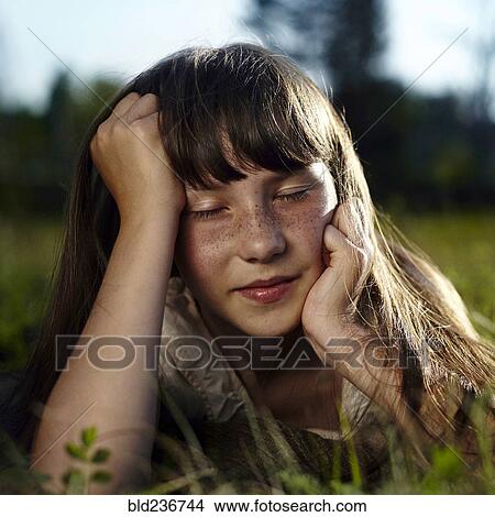 Caucasian girl with freckles laying in grass View Large Photo Image Picture - Caucasian girl with freckles laying in grass. Fotosearch