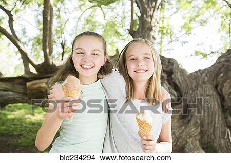 Picture - Caucasian girls eating ice cream cones. Fotosearch