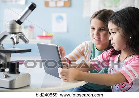 Caucasian girls sharing digital tablet in classroom View Large Photo Image Stock Photo - Caucasian girls sharing digital tablet in classroom. Fotosearch
