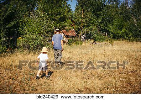 Caucasian grandfather and grandson walking in field View Large Photo Image Stock Photo - Caucasian grandfather and grandson walking in field. Fotosearch
