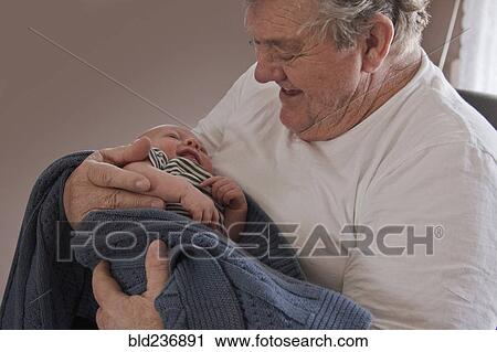 Stock Image - Caucasian grandfather holding baby grandson. Fotosearch