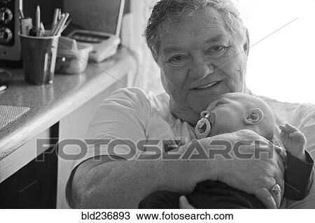 Stock Image - Caucasian grandfather holding baby grandson. Fotosearch