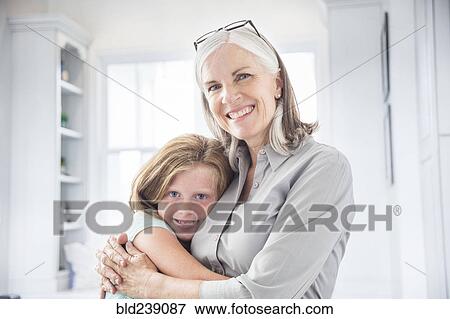 Stock Photo - Caucasian grandmother and granddaughter hugging. Fotosearch