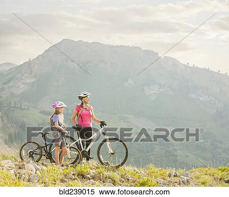 Caucasian grandmother and granddaughter standing with mountain bikes View Large Photo Image Stock Photography - Caucasian grandmother and granddaughter standing with mountain bikes. Fotosearch
