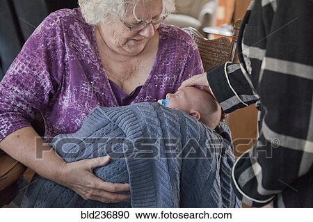 Stock Image - Caucasian grandmother holding baby grandson. Fotosearch