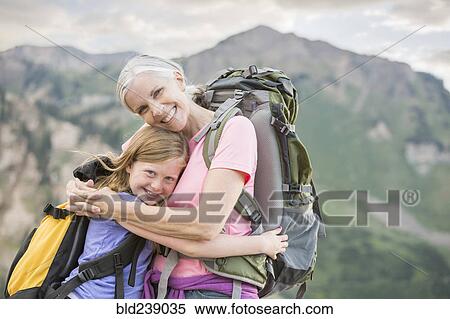 Stock Photography - Caucasian grandmother hugging granddaughter on mountain. Fotosearch