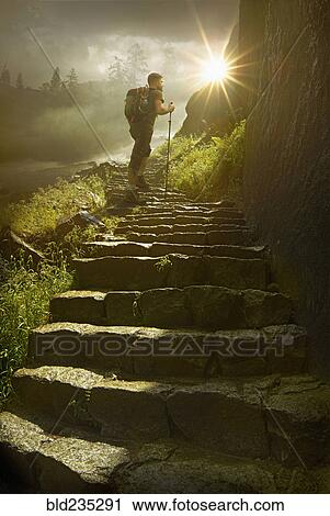 Caucasian hiker holding walking stick on sunny mountain path View Large Photo Image Stock Image - Caucasian hiker holding walking stick on sunny mountain path. Fotosearch