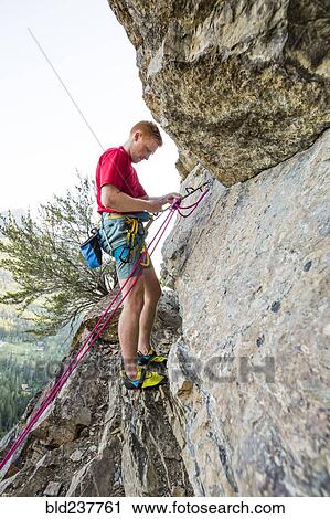 Caucasian man adjusting rope while rock climbing View Large Photo Image Stock Image - Caucasian man adjusting rope while rock climbing. Fotosearch