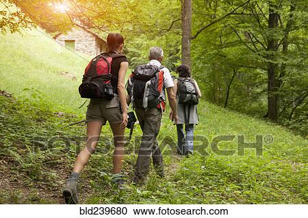 Stock Image - Caucasian man and women hiking on hill. Fotosearch
