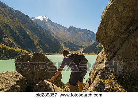 Caucasian man backpacking near mountain lake View Large Photo Image Stock Photo - Caucasian man backpacking near mountain lake. Fotosearch