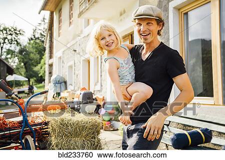 Stock Image - Caucasian man carrying daughter. Fotosearch