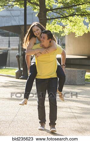 Caucasian man carrying girlfriend piggyback in park View Large Photo Image Stock Image - Caucasian man carrying girlfriend piggyback in park. Fotosearch