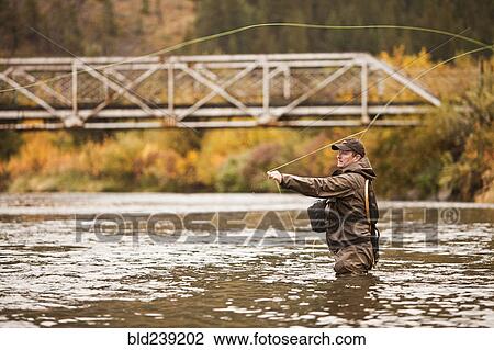 Caucasian man casting in river View Large Photo Image Stock Image - Caucasian man casting in river. Fotosearch