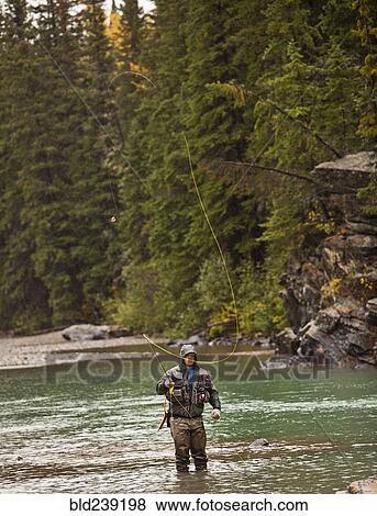 Caucasian man casting in river View Large Photo Image Stock Photo - Caucasian man casting in river. Fotosearch